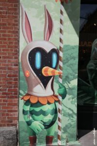 Street art de Soul Rider montrant un personnage imaginaire avec masque cosmique et oreilles de lapin peint sur un mur.