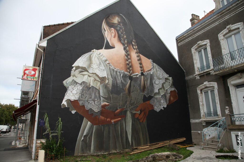 Street art de Javier Barriga montrant un portrait féminin hyperréaliste peint sur un grand mur à Boulogne-sur-Mer.