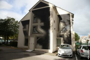 Street art de Shozy en trompe-l’œil sur une maison à Boulogne-sur-Mer avec formes géométriques en perspective.