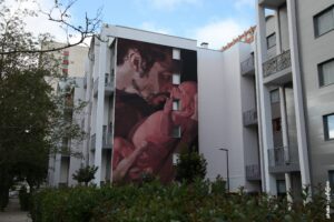 Street art de Hélène Planquelle montrant un père tenant son bébé sur une façade d’immeuble à Boulogne-sur-Mer.