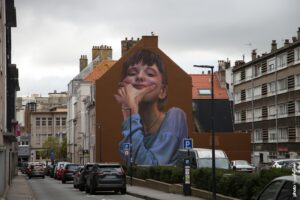 Fresque street art Case Maclaim représentant un portrait féminin hyperréaliste en grand format.