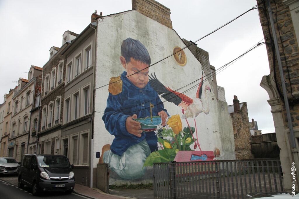 Fresque murale de Jade Rivera montrant un enfant en uniforme avec un oiseau et des fleurs en street art