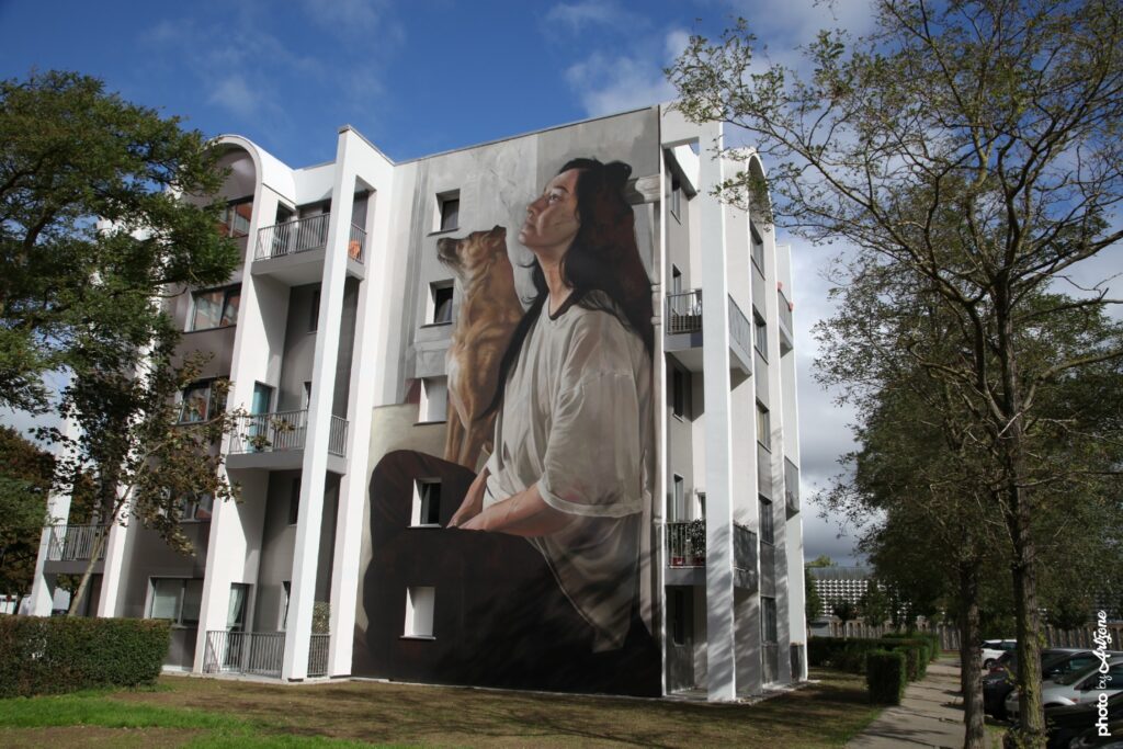 Street art monumental de Liam Bononi à Boulogne-sur-Mer représentant une femme contemplative accompagnée de son chien.