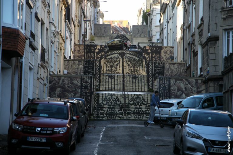 Installation de street art de Borondo sur une grille métallique monumentale en milieu urbain