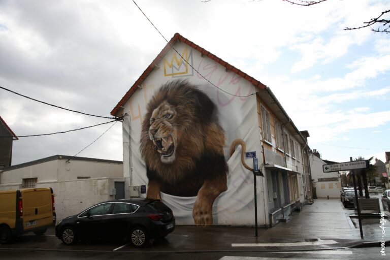 Fresque street art Scaf Oner montrant un lion hyperréaliste rugissant sur pignon