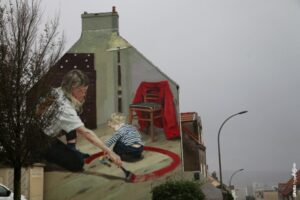 Fresque street art Helen Bur montrant une scène intime mère et enfant sur pignon