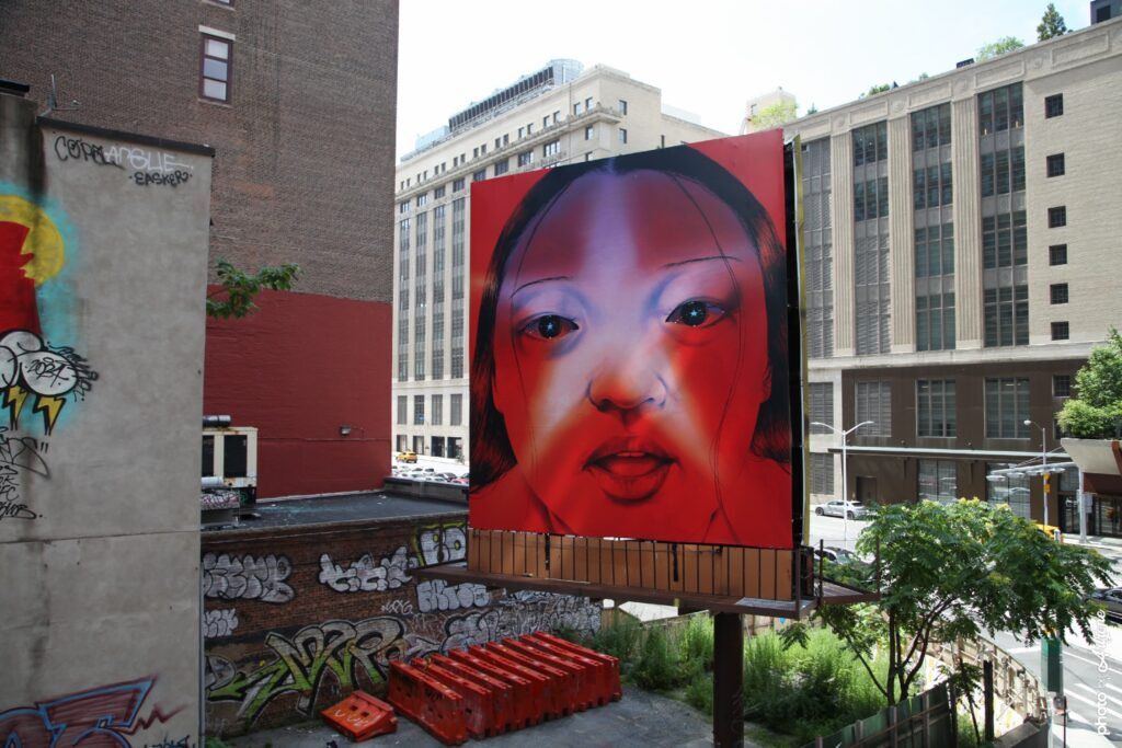 Fresque street art Sasha Gordon portrait féminin rouge monumental en ville