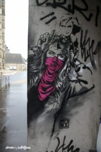 Œuvre street art RNST pochoir femme noir et blanc avec foulard rose