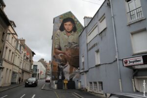 Street art d’Evoca avec portrait réaliste d’une jeune femme et son chien en fresque murale monumentale.