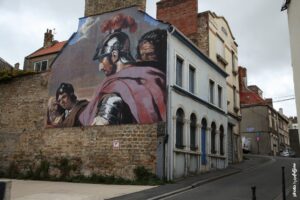 Street art d’Andrea Ravo Mattoni reproduisant une scène classique avec personnages en armure sur un mur urbain.
